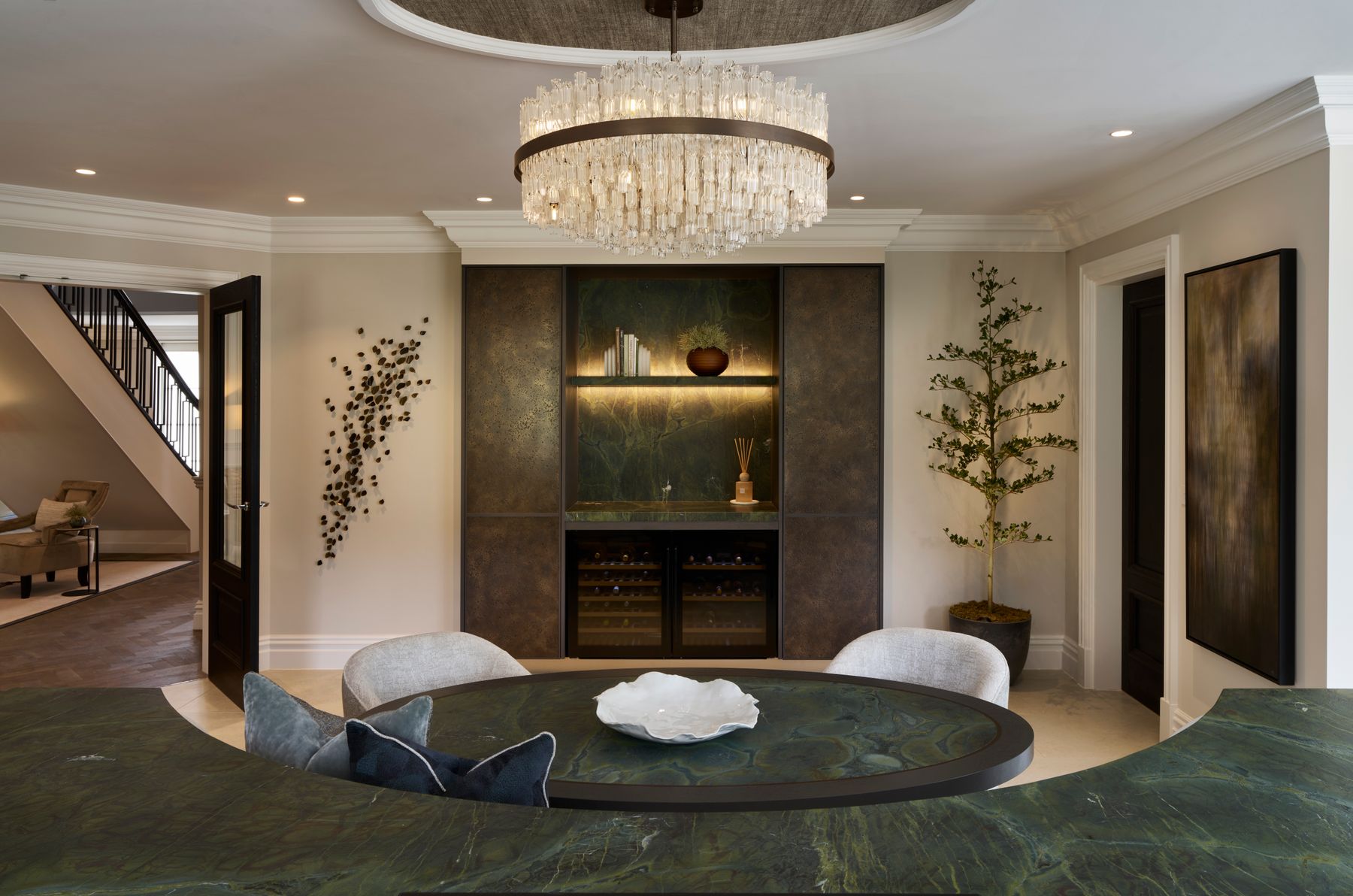 Residential salon with sculptural chandelier and green marble tables
