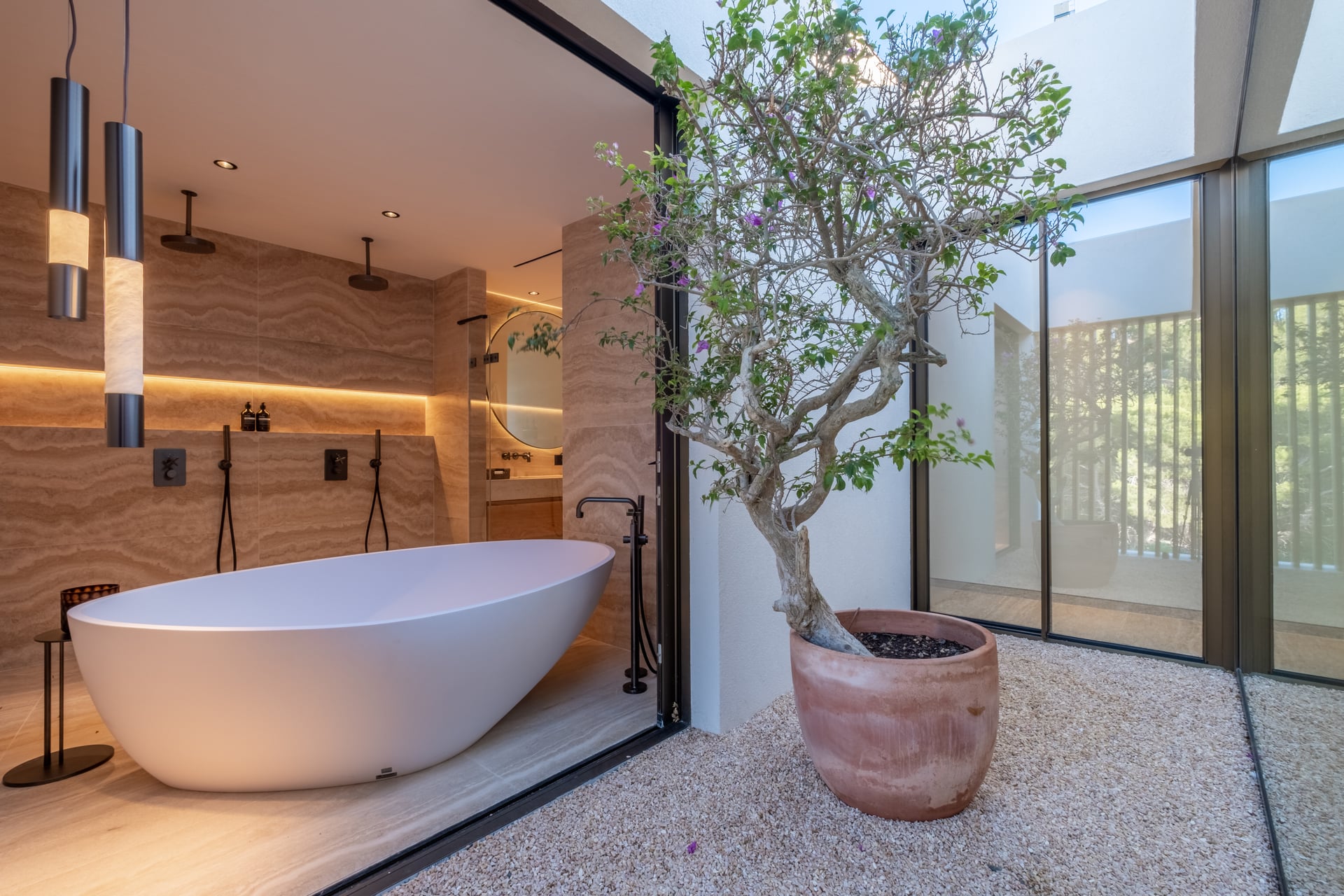 Freestanding bath beside a planted courtyard